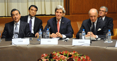U.S. Secretary of State John Kerry (front, center) sits between Chinese Foreign Minister Wang Yi (left) and French Foreign Minister Laurent Fabius (right) at the United Nations Headquarters after the P5+1 nations reached an interim nuclear deal with Iran in Geneva, Switzerland, on November 24, 2013. Credit: U.S. State Department.
