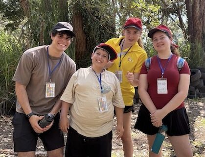 Junior camper immersed in nature with volunteer companions.