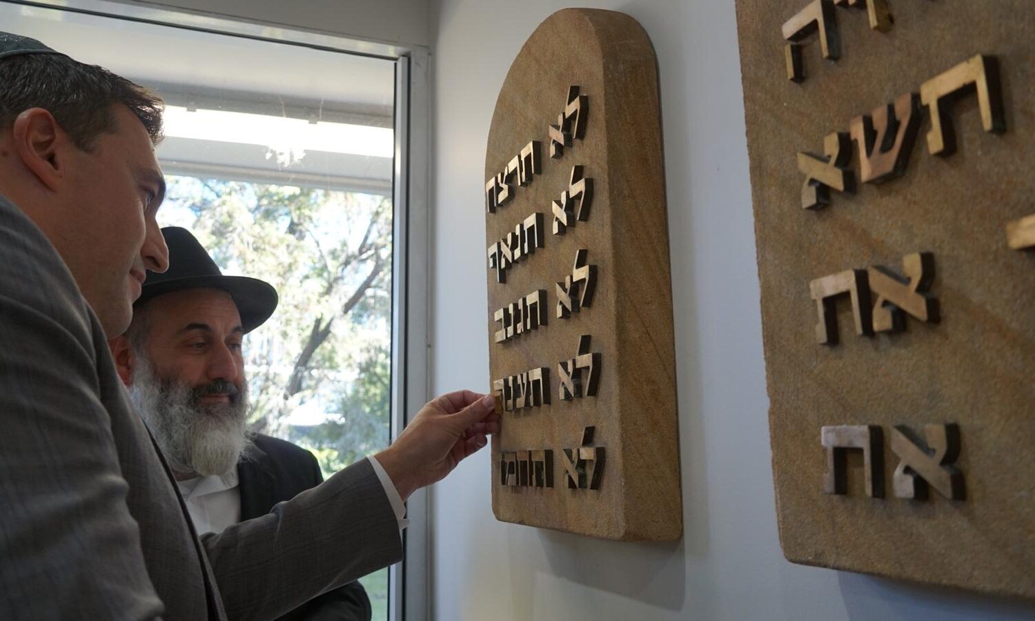 Joshua Lewis inserting the missing letters into the Ten Commandments tablet, which was saved from the arson attack on the Bankstown Synagogue.Joshua is the son of Max Lewis and the great-grandson of Bernard Lewis.