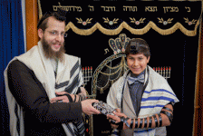 Rabbi Yisroel Kohn giving Ron a gift from Jewish Care