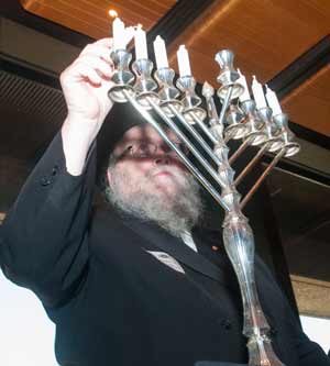 Rabbi Pinchus Feldman lights the Menorah