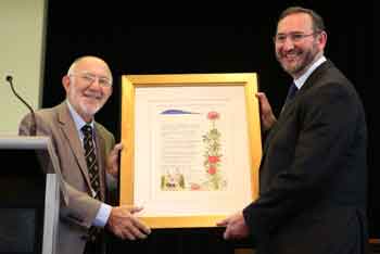 Synagogue president Michael Gold make a presentation to Rabbi Jeremy Lawrence photo: Gisell Haber